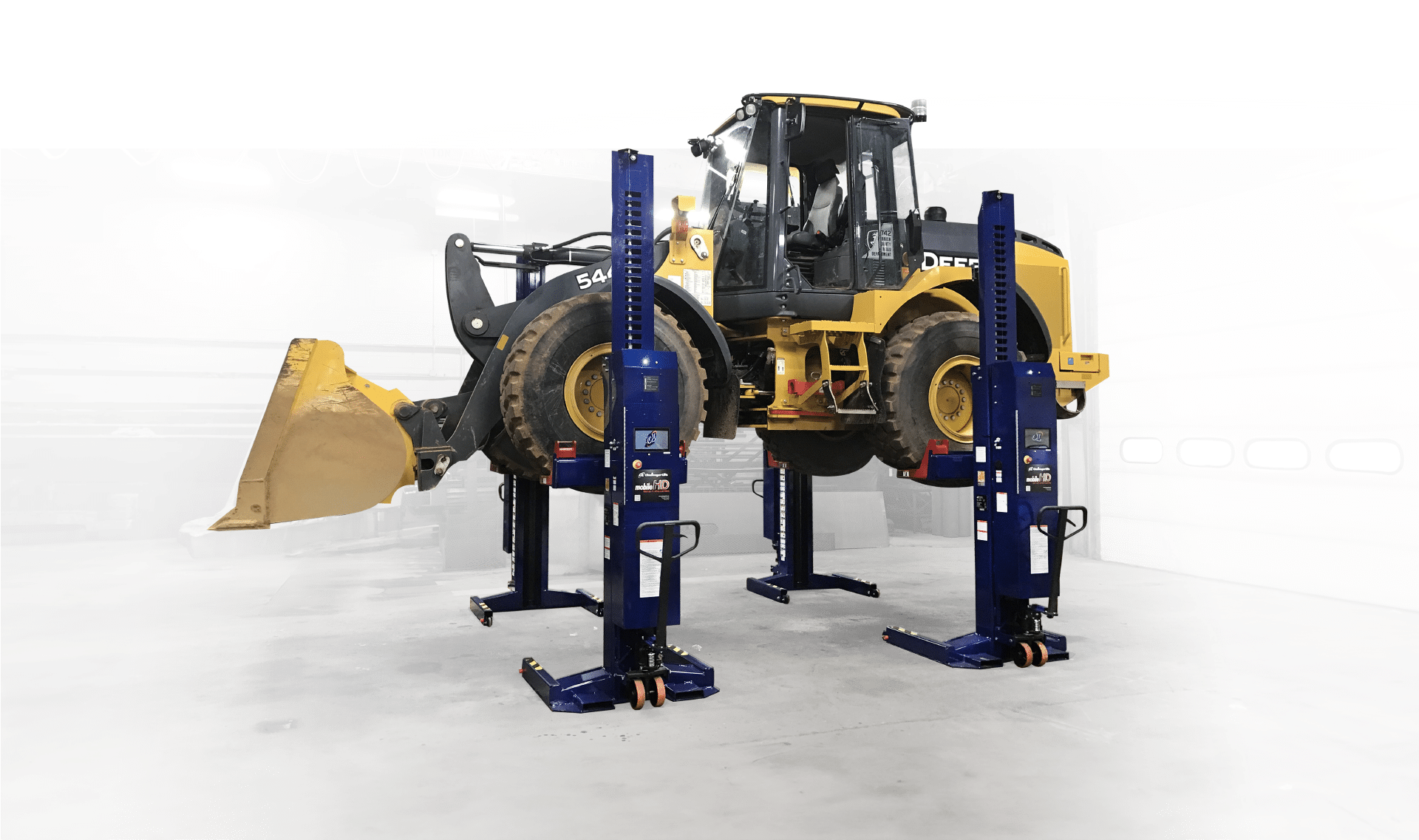 A front loader being lifted by Challenger mobile column lifts